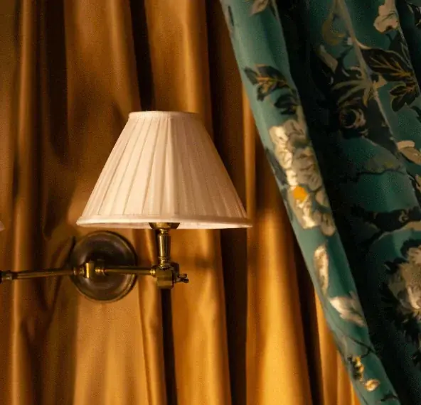 Applique et rideaux en soie dorée d'une chambre de l'Hôtel de Buci, Paris 6