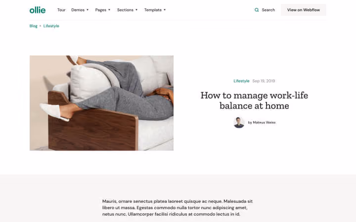 Person in gray sweatpants relaxing on a modern wooden-arm lounge chair.