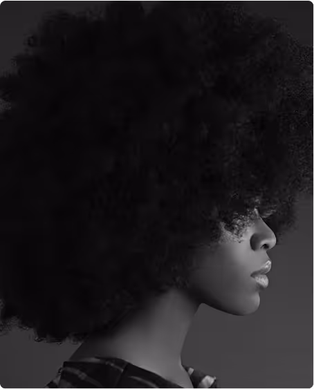 Profile of a woman with voluminous curly hair against a plain background.