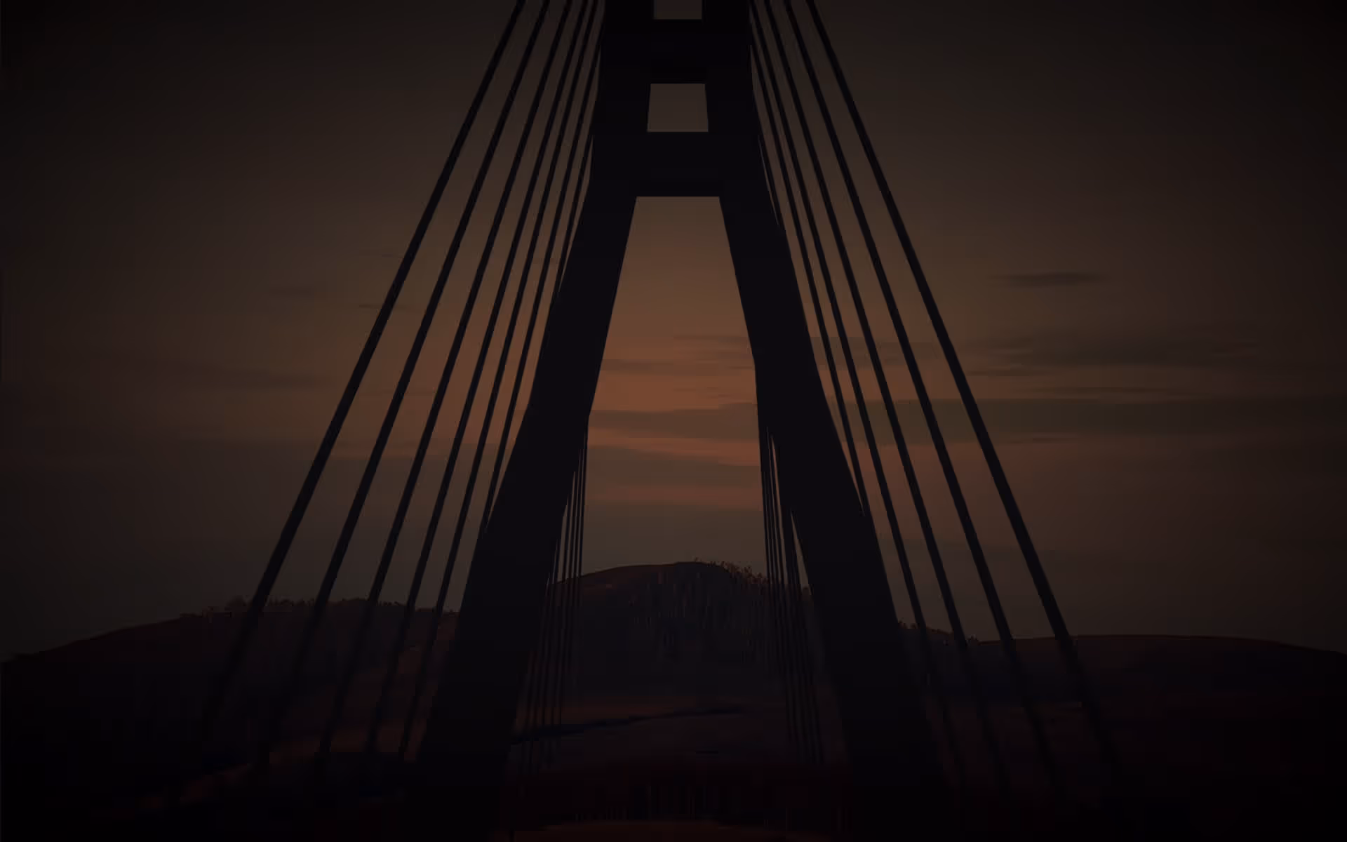 Silhouette of a cable-stayed bridge tower and cables against a dusky sky at sunset.