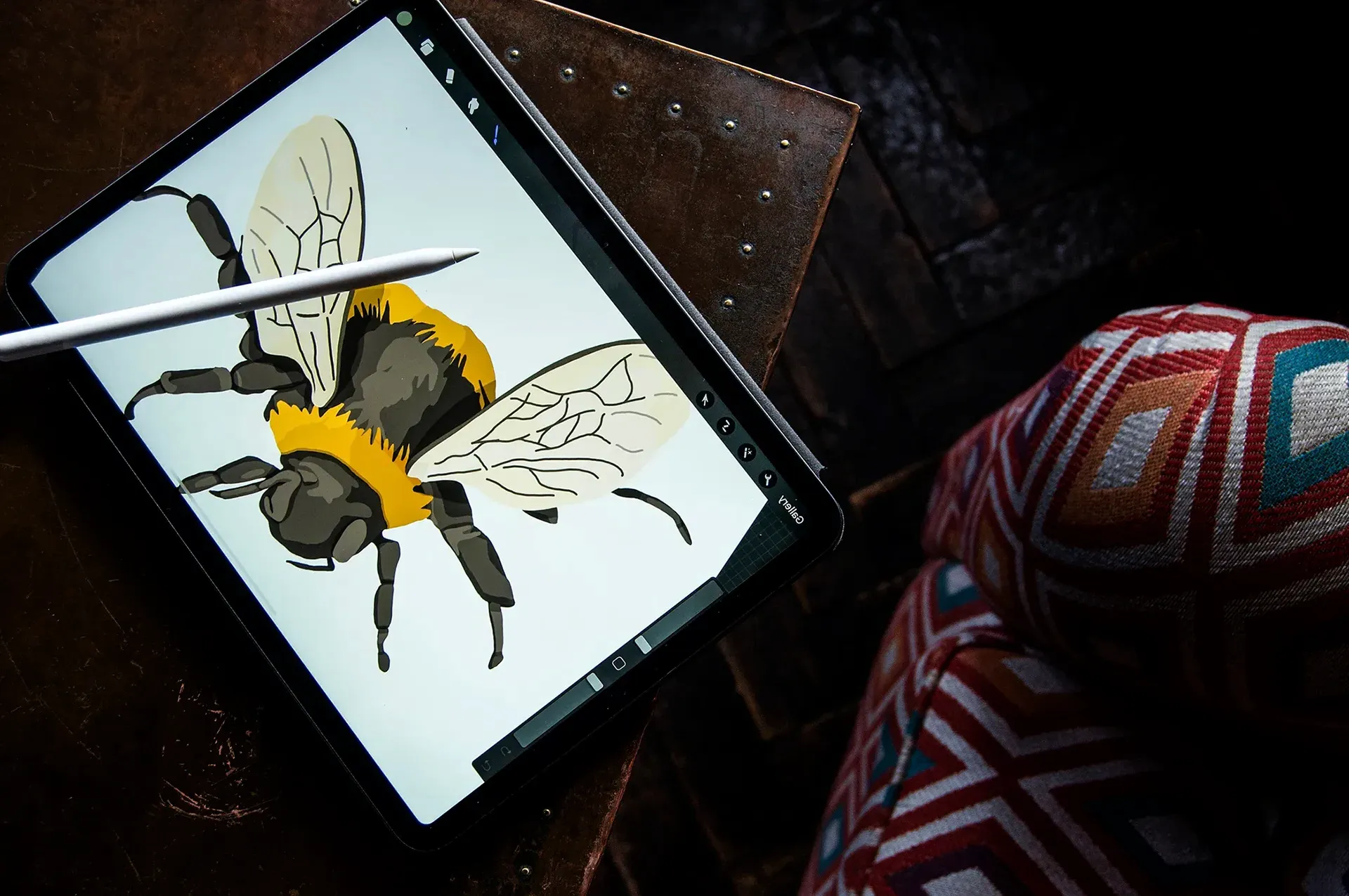 Digital drawing of a bee on a tablet with a stylus pen resting on the screen.