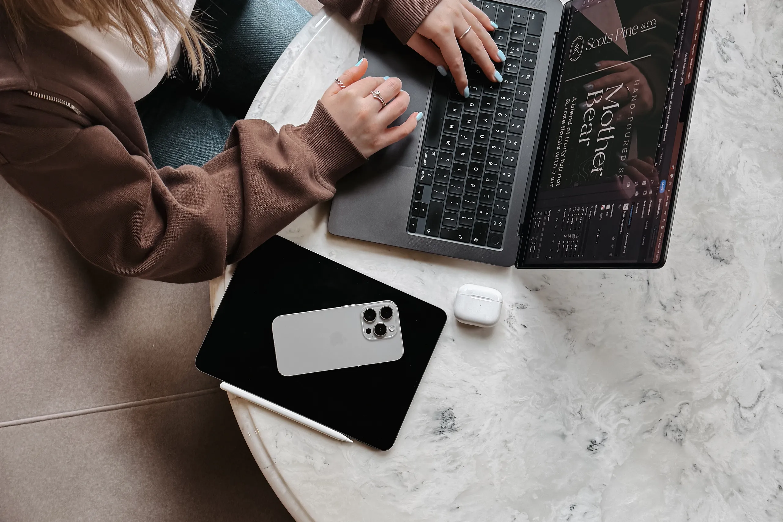 Aerial view of designer working on laptop with phone and iPad