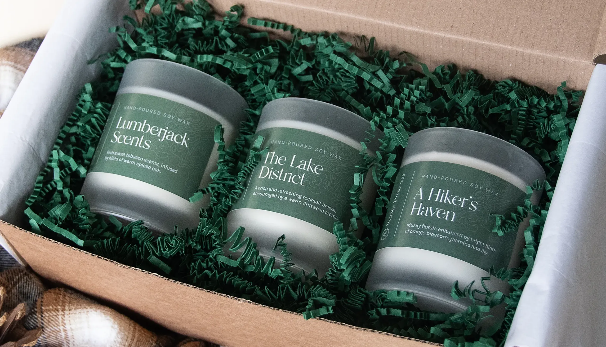 3 candles displaying their labels whilst in cardboard box