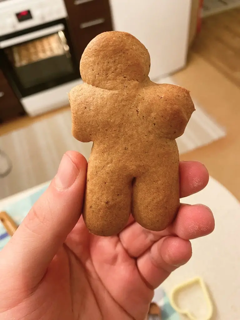 hand holding a cookie that looks like a statue without arms