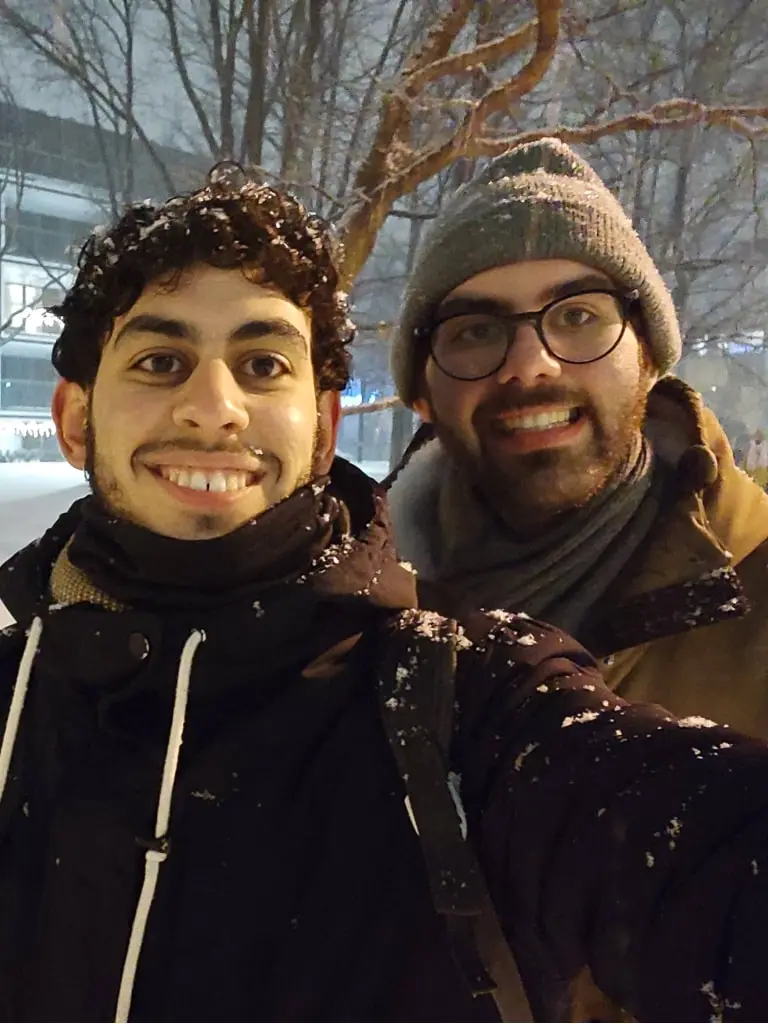 Antonis and Savvas smiling to the camera while it's snowing 