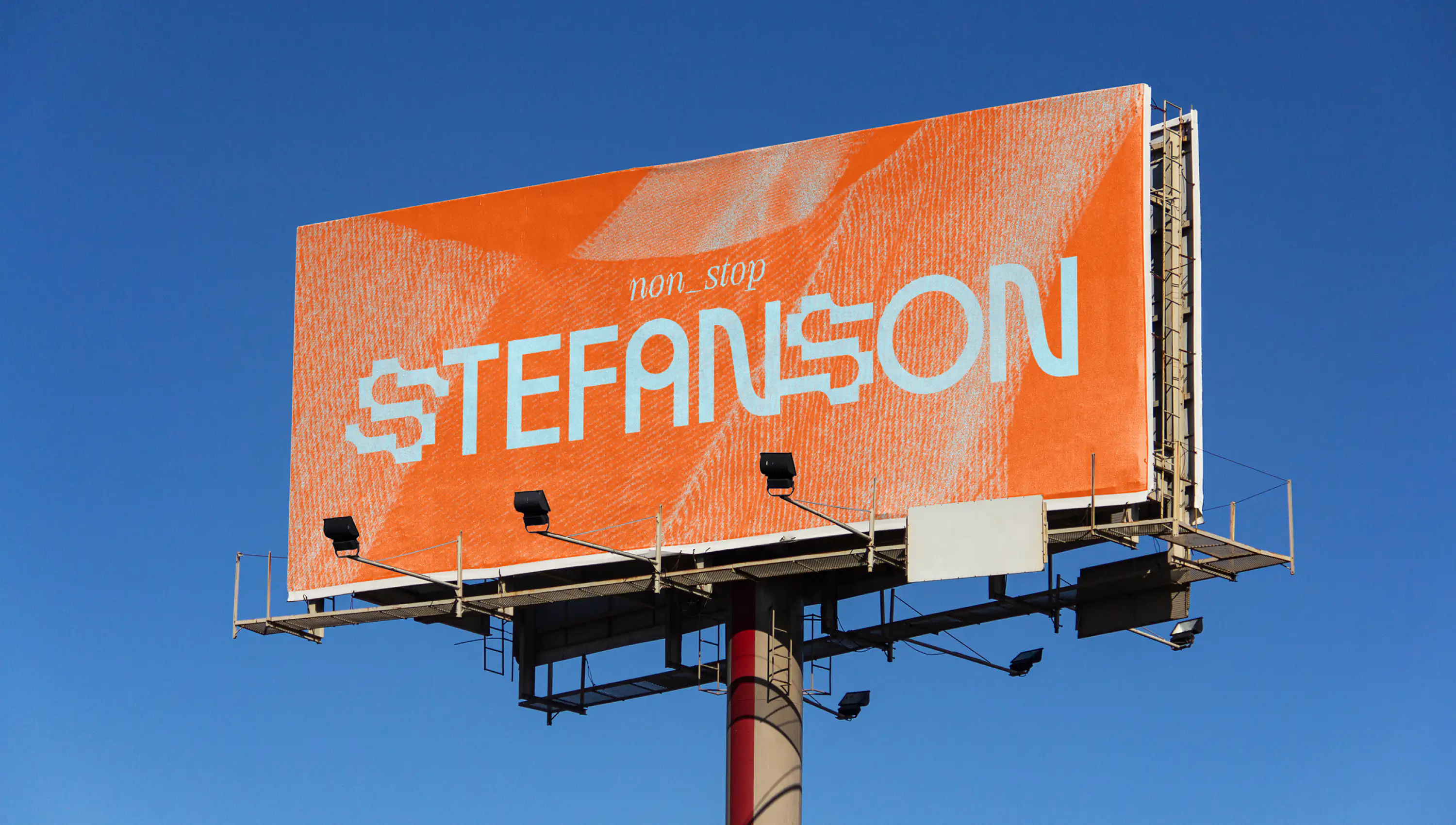Large orange billboard with “Stefanson” typography against clear blue sky designed by Orgcaos for Swiss artist Stefan Degen