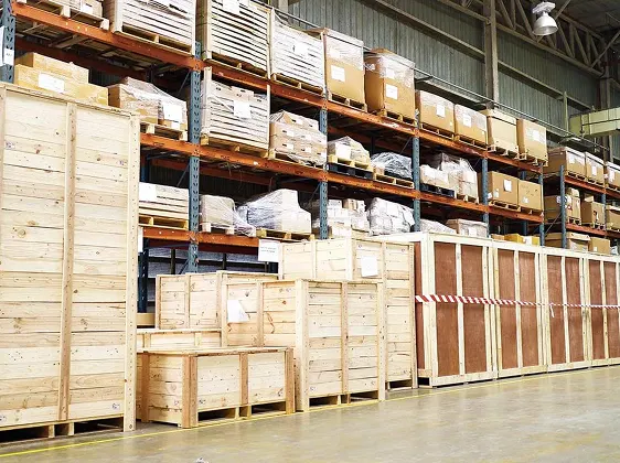 Warehouse interior with large wooden crates and boxes stacked on metal shelving.