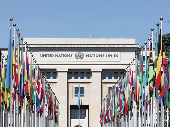 United Nations building facade with rows of international flags on either side.
