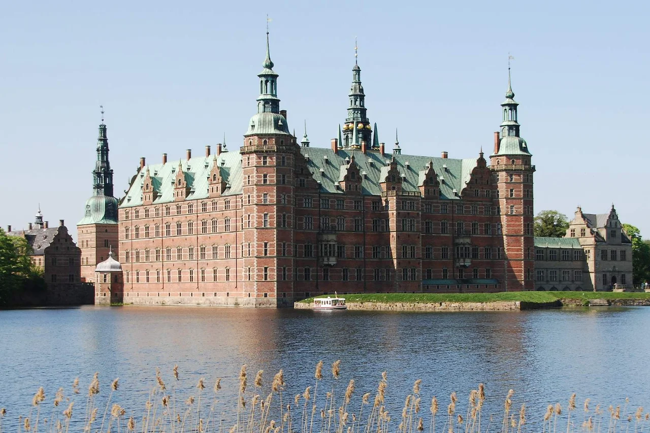 Historic Frederiksborg Castle with Renaissance architecture reflected in lake water near Copenhagen
