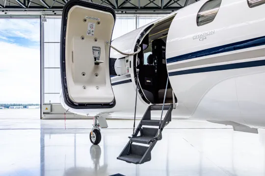 Otwarte drzwi i schody prywatnego odrzutowca Citation CJ4 w jasnym hangarze