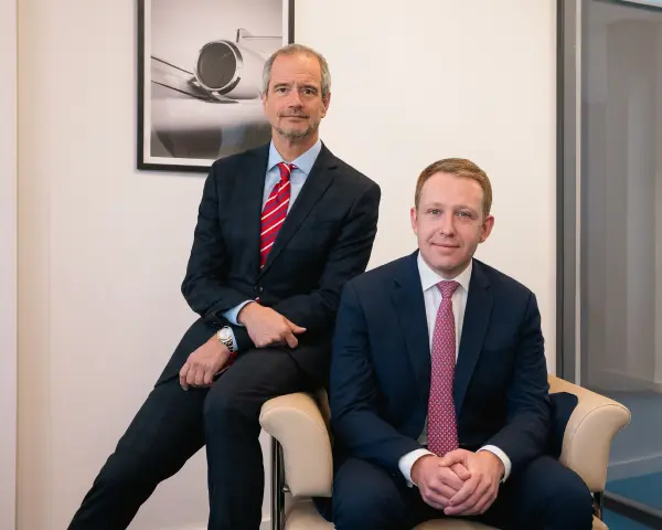 Eymeric Segard und Guillaume Launay sitzen auf einem Stuhl im Büro von LunaJets in Genf