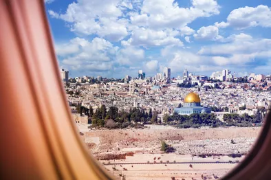 Une perspective unique sur le paysage urbain de Jérusalem, incluant le Dôme du Rocher, vue depuis le hublot d'un avion.