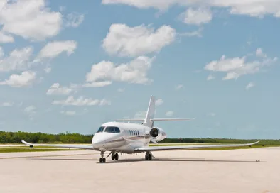 Ein eleganter Privatjet parkt auf einem sonnigen Rollfeld in Mexiko.