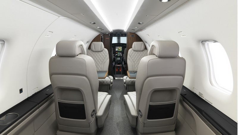 Interior cabin view of Pilatus PC-12 NGX showing beige leather seats, avionics, windows, and streamlined fuselage design.