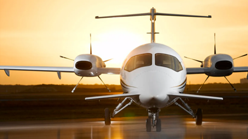 Front view of a Piaggio P.180 Avanti at the airport at sunset.