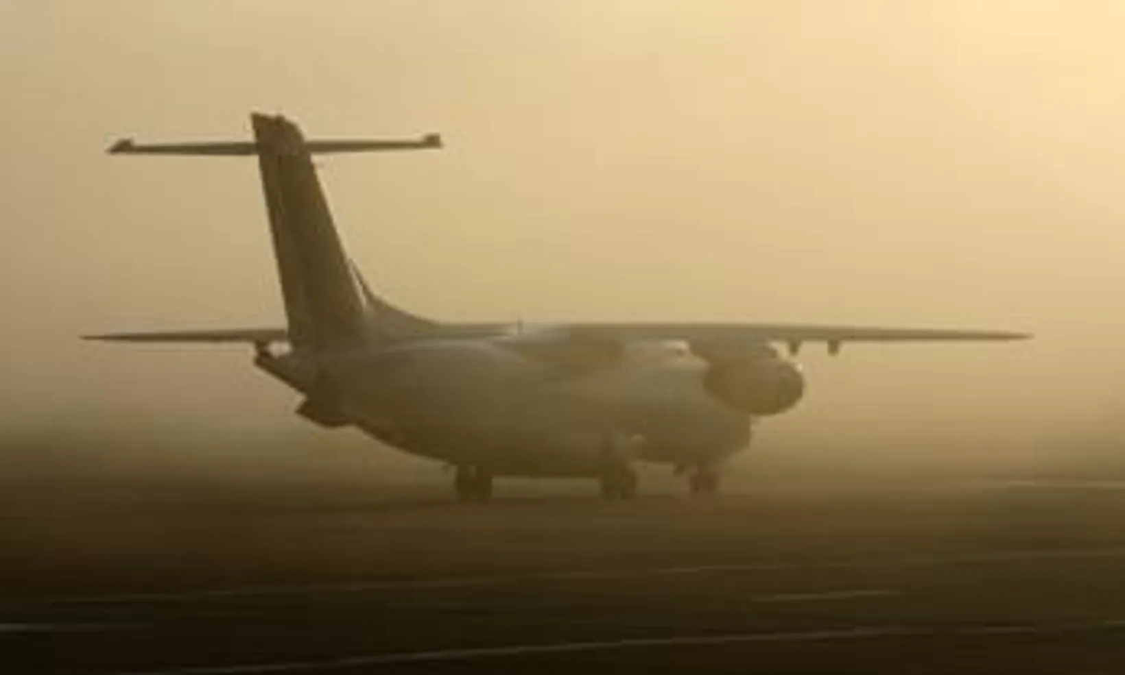 Fairchild Dornier 328 Executive turboprop aircraft parked on runway in dusty conditions, side view showing twin engines an...