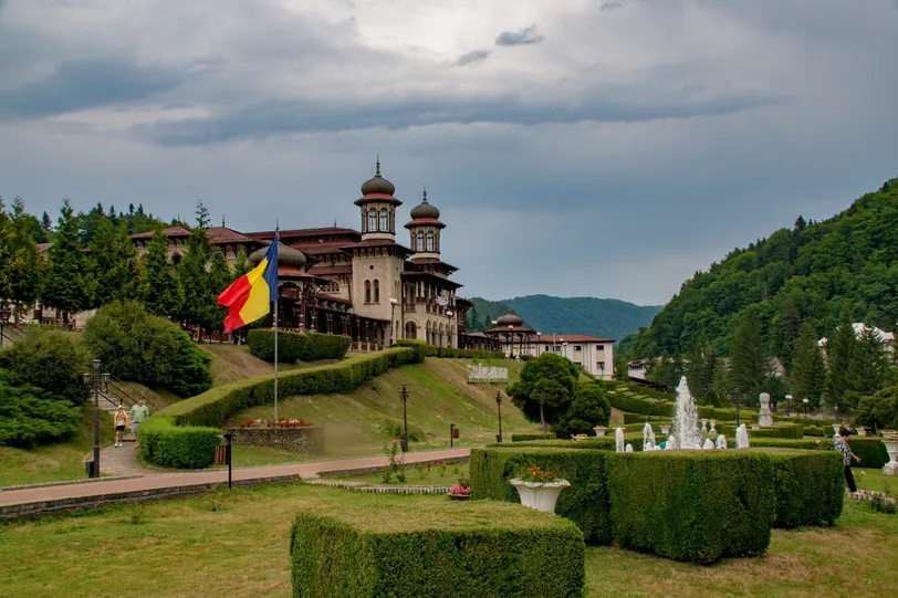 Un castello storico a Bacău, in Romania, circondato da una vegetazione lussureggiante e giardini.