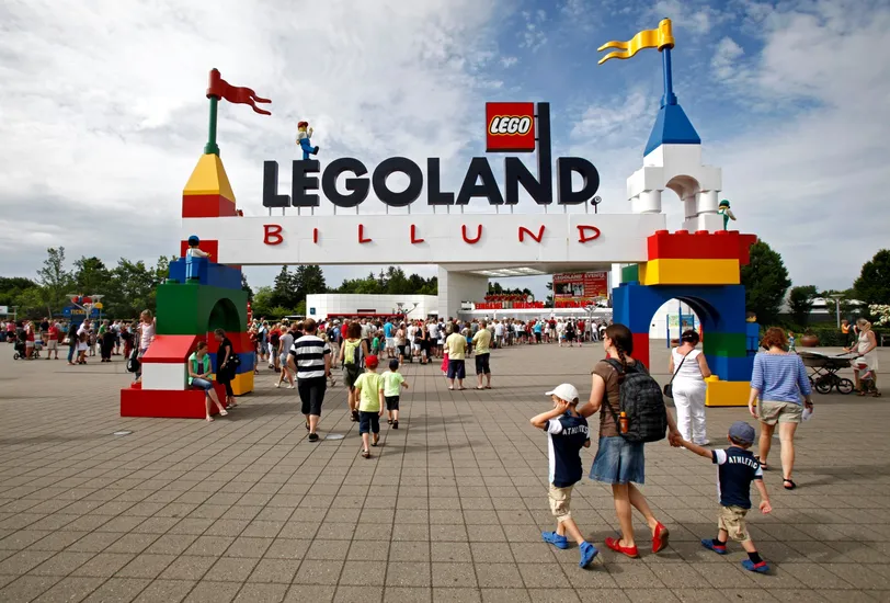 Ingresso a Legoland Billund, Danimarca, con le famiglie che camminano attraverso colorati archi a tema Lego.