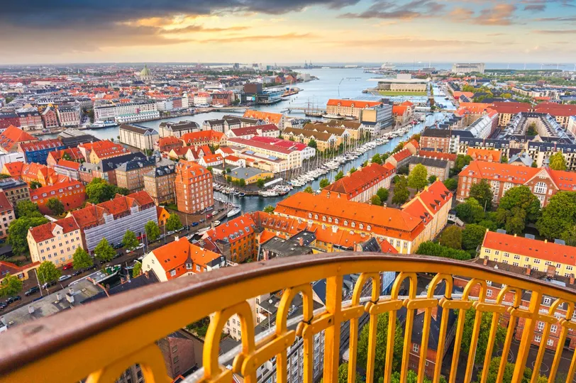 Veduta aerea dei canali e degli edifici storici di Copenaghen con il porto sullo sfondo durante il tramonto.