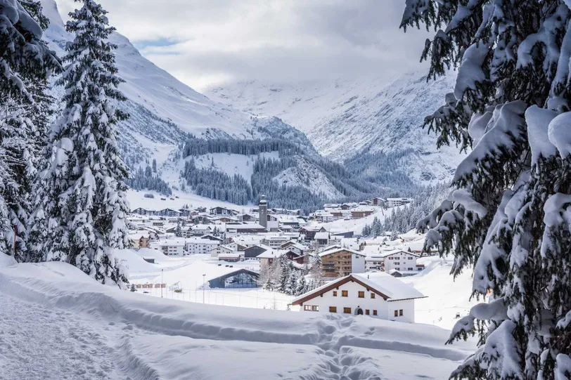 Il pittoresco villaggio innevato di Lech, in Austria, incastonato tra le Alpi, rinomato per le sue stazioni sciistiche di lusso.