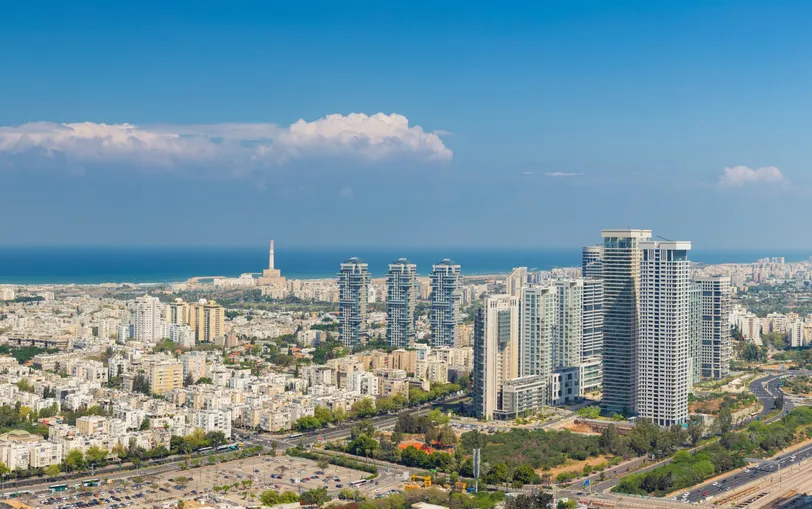 Une vue aérienne époustouflante de la ligne d’horizon moderne de Tel Aviv, avec des gratte-ciel et la vaste mer Méditerranée en arrière-plan.