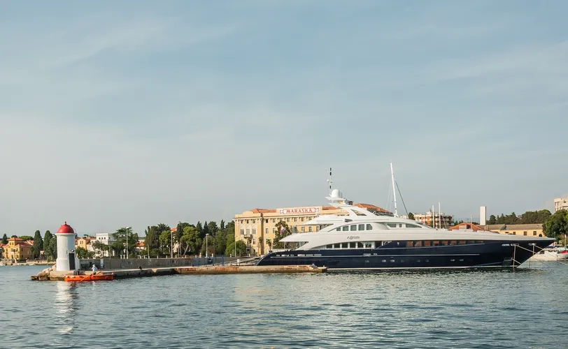 A horvátországi Zadarban kikötött luxusjacht, amely tükrözi a nyugodt vizet és a tengeri varázst, tökéletes kiegészítője egy magánrepülési utazásnak.