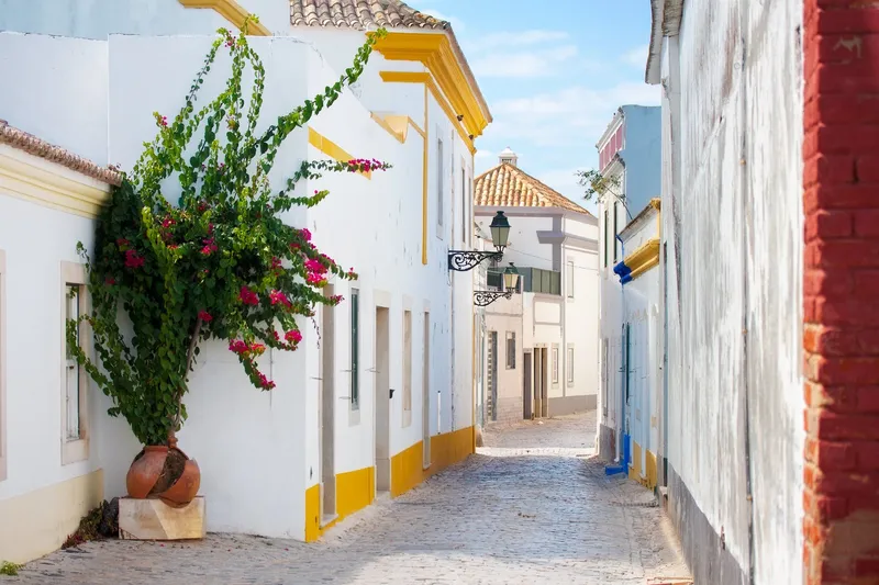 Enge Gasse mit hellen Häusern in Faro