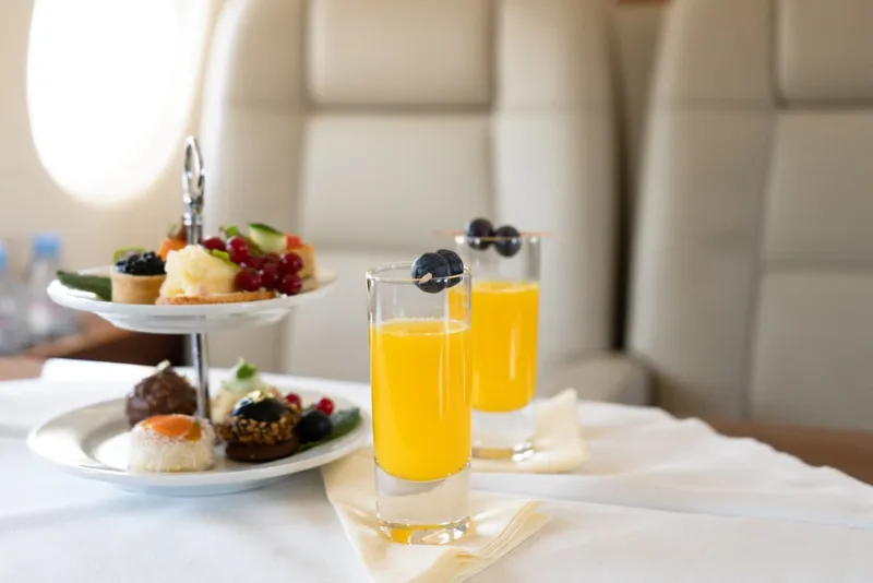Un delicioso plato de cupcake y 2 cócteles servidos en un vuelo en jet privado