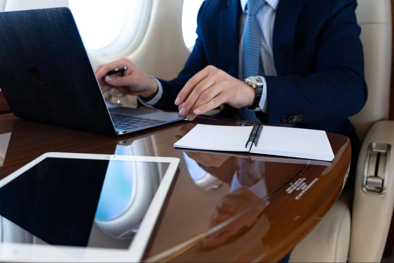 A businessman working on a laptop on a private jet