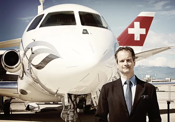 Trzymany w dłoni smartfon z ekranem aplikacji do rezerwacji prywatnych odrzutowców w stylu Ubera