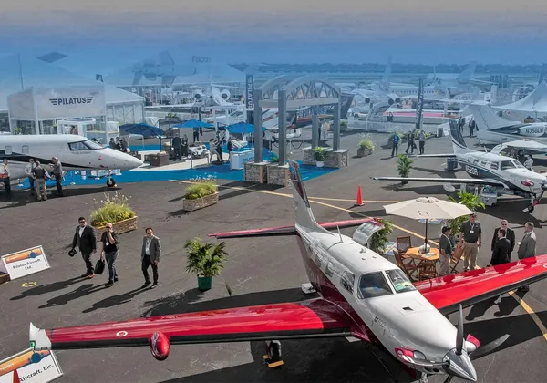 Wystawa plenerowa NBAA‑BACE 2022 z przedsiębiorcami i gośćmi oglądającymi małe samoloty i stoiska