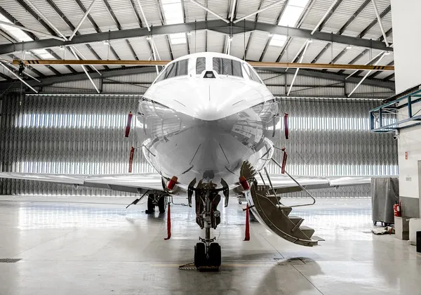 Widok z przodu samolotu Dassault Falcon 7X ze schodami opuszczanymi w hangarze