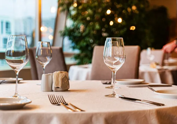 Elegancki zestaw stołowy do restauracji z białymi obrusami, kieliszkami do wina, sztućcami i serwetkami