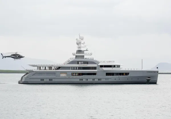 Czarny helikopter unoszący się nad lądowiskiem dla helikopterów luksusowego jachtu na morzu