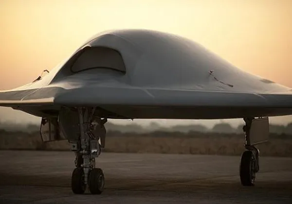 Bezzałogowy dron bojowy stealth zaparkowany na pasie startowym o zmierzchu