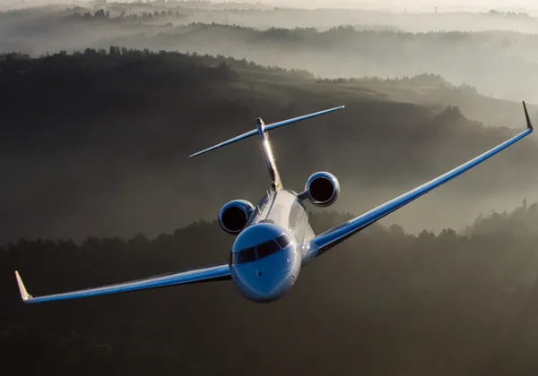 Samolot biznesowy Embraer Phenom 300 lecący nad linią brzegową