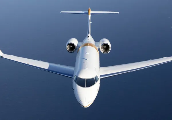 Samolot biznesowy Bombardier Challenger 3500 lecący nad surowymi górami