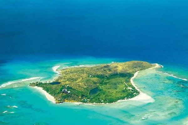 Aerial view of a small tropical island with turquoise lagoons and reef
