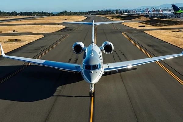 Luxurious private jet cabin with beige seats, glossy table and designer magazine