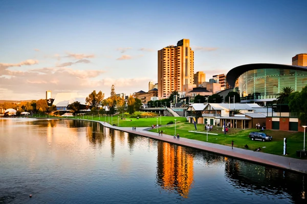 Skyline moderno di Adelaide che si riflette sul fiume con parco e sentiero