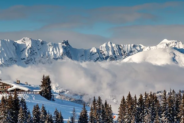 Foto de la cima de una estación de esquí en Megève en Francia con montañas nevadas de fondo