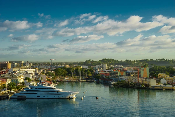Front de mer de Pointe-à-Pitre avec un grand yacht, des bâtiments et un petit bateau