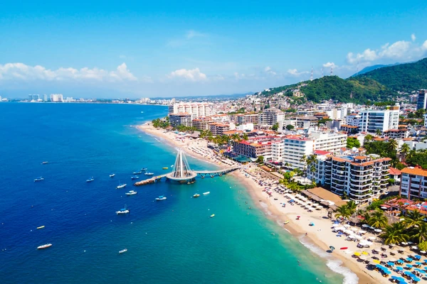 Ville balnéaire de Puerto Vallarta avec un quai en forme de voile, des hôtels et une baie turquoise