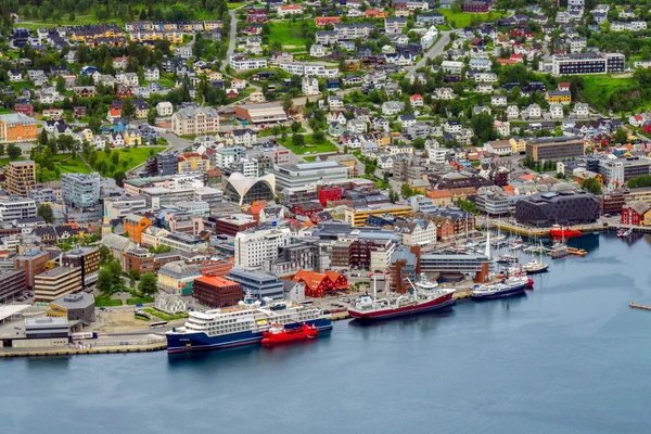 Romantikus kilátás egy párra, akik a lélegzetelállító sarki fényt nézik a norvégiai Tromsø felett, megörökítve a varázslatos északi fény élményét.