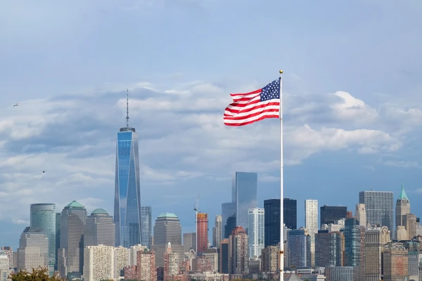 Vue de la ligne d'horizon de New York avec un drapeau américain au premier plan