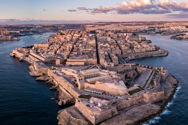 Aerial view of Valletta, Malta's fortified capital city surrounded by Mediterranean waters at golden hour