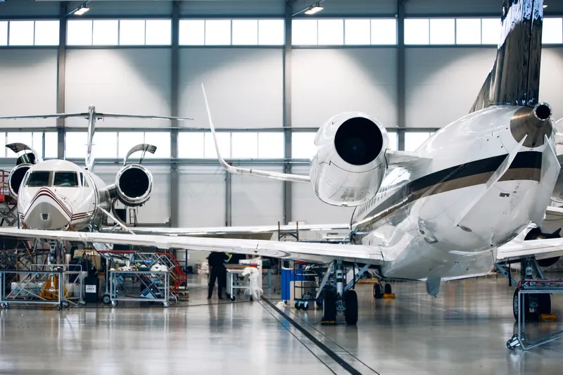 Jets dans un hangar pour maintenance, illustrant la création d'emplois dans le secteur de l'aviation privée.