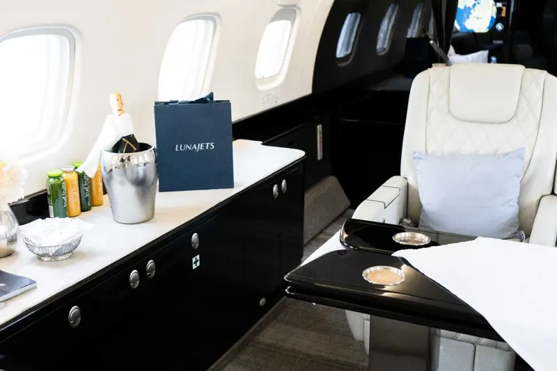 Intérieur luxueux d'un jet privé avec champagne, incarnant l'expérience de voyage ultime.