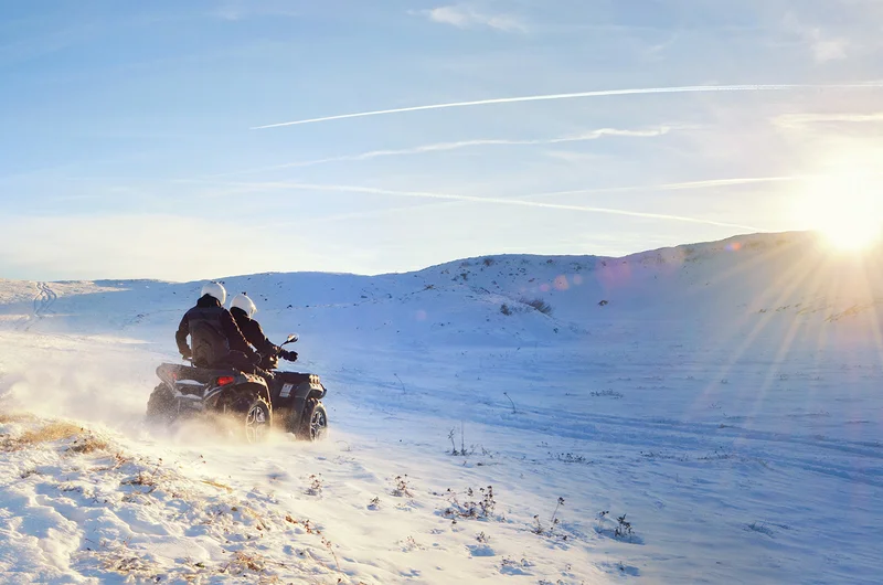 Para jadąca buggy po śniegu o wschodzie słońca