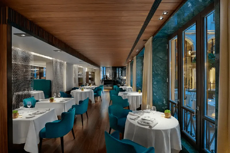 Sala da pranzo vetrata con tavoli apparecchiati da Seta, Mandarin Oriental, Milano